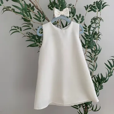 Vestido infantil off-white de linho, sem mangas e em corte trapézio, em cabide azul com laço do mesmo tecido