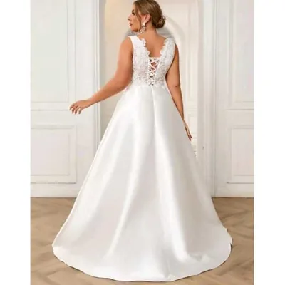 Noiva de costas com vestido branco sem mangas, renda e amarração nas costas e saia longa acetinada em evasê
