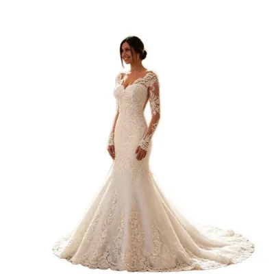 Noiva de coque baixo com vestido sereia marfim de renda, mangas longas transparentes, decote em V e cauda arredondada