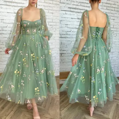Vestido verde de tule com florzinhas bordadas, corpete de alças finas, mangas bufantes transparentes e amarração nas costas