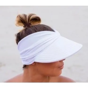 Mulher na praia com viseira turbante branca de aba larga e faixa franzida, cabelo preso em coque alto aparecendo por cima